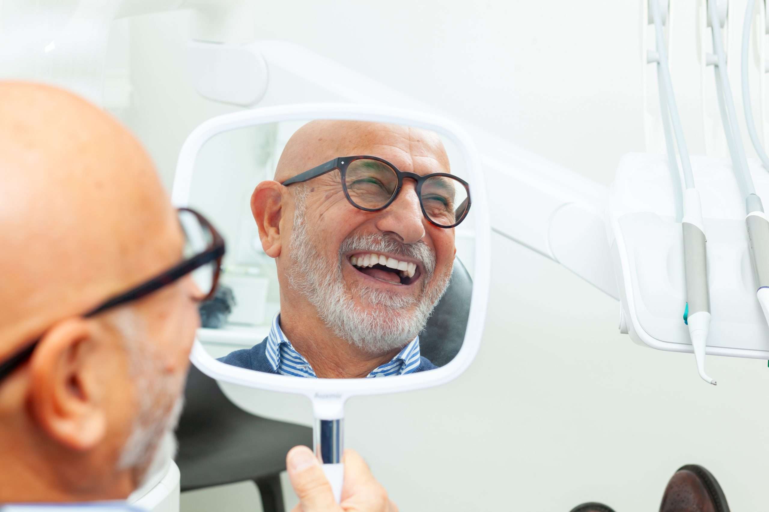 all-on-4-dental-implants-man-smiling-in-mirror